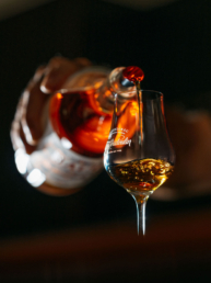 D&eacute;tail d'un flacon d'Armagnac de prestige mettant en valeur la robe ambr&eacute;e.