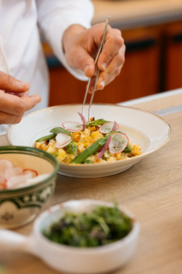 Gestes pr&eacute;cis du chef cuisinier dressant une assiette color&eacute;e, restaurant gastronomique &agrave; Pau