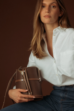 Photographie lookbook de marque, présentant un sac en cuir de la marque Erro, portée par un modèle femme.