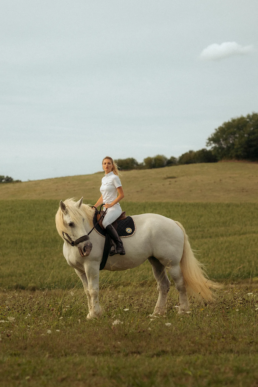 Photographie d'une cavalière et son cheval avec un tapis de selle de la marque Balzane.