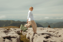 Modèle marchant en montagne au Pays Basque avec le grand cabas en cuir vert Liza de la marque Erro.